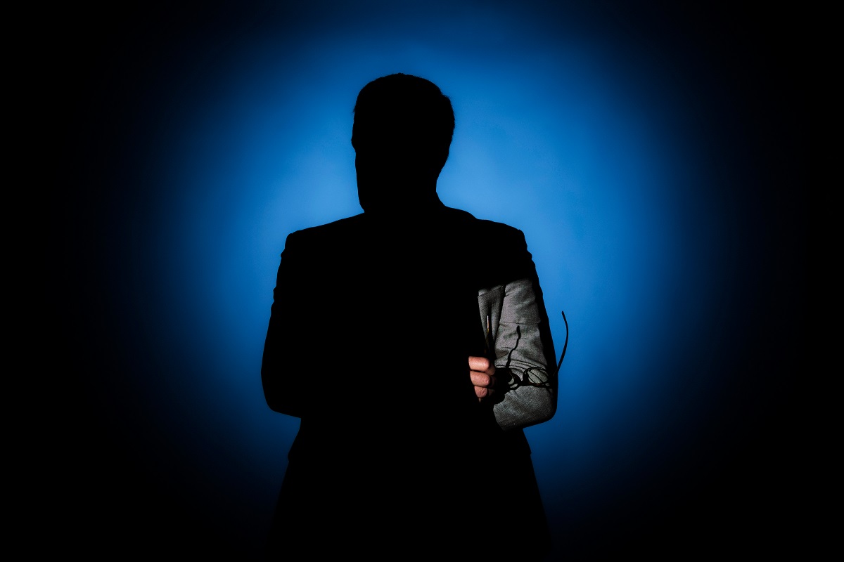 Person i siluett som håller i glasögon